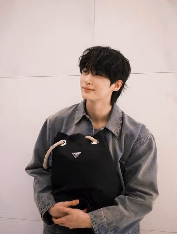 Byun Woo-seok sosteniendo un bolso de Prada como un bebé
