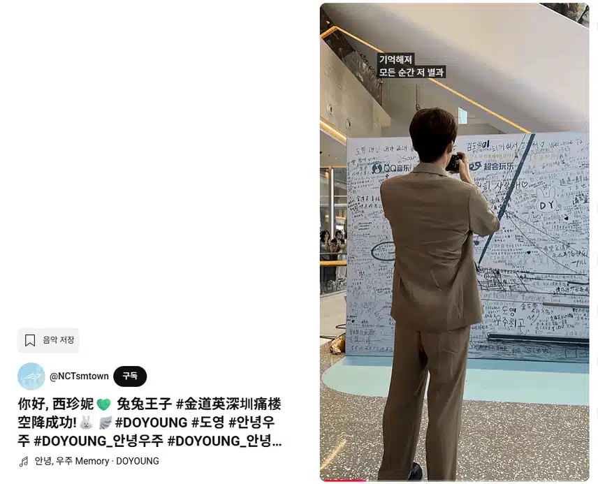 Doyoung looks happy as he takes pictures while looking at the messages written by fans~~